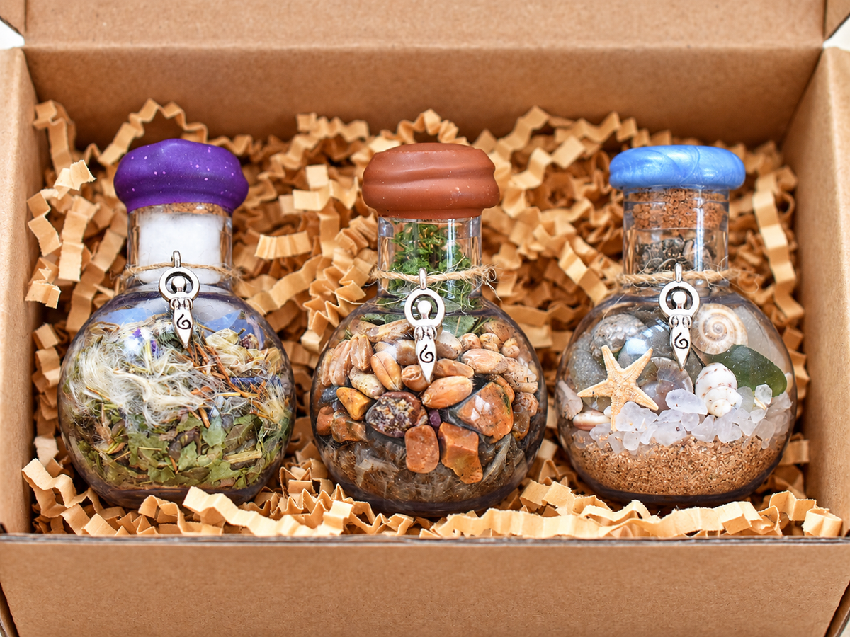 Three Yarrow Moon Offering Jars nestled in shredded paper inside a kraft presentation box.