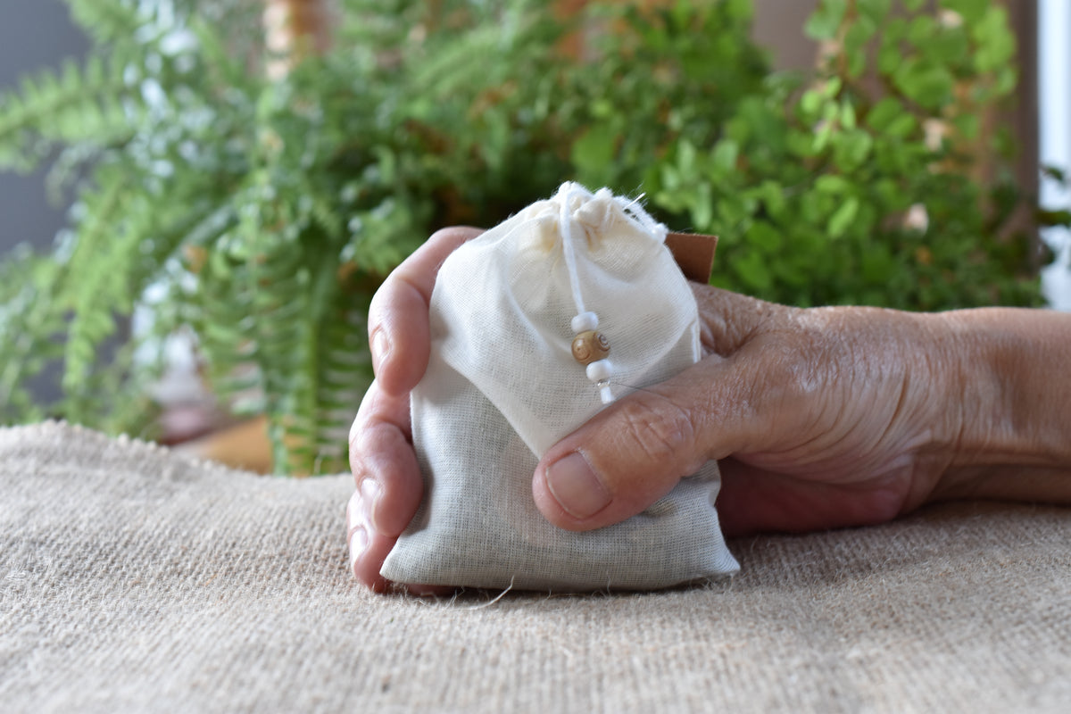 The Moth Familiar Pouch shown close up with its handmade cotton pouch and natural contents.